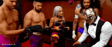 a group of men and a woman are standing in a locker room .