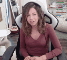 a woman wearing headphones is sitting in a chair with a bunch of messages in the background