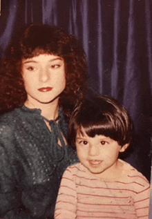 a woman and a child are posing for a picture