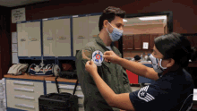a man wearing a mask has a patch on his jacket