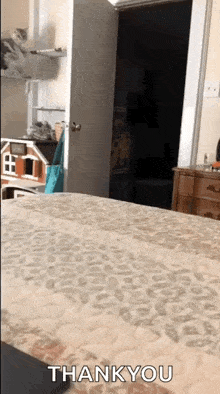 a bed with a leopard print blanket and the words thank you written on it