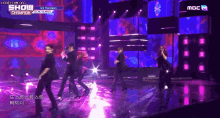 a group of people are dancing on a stage with the words show champion on the bottom