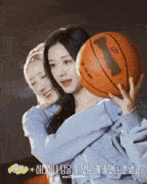 two girls hugging a spalding basketball with asian writing on the bottom