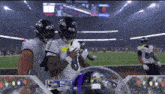 a ravens football player stands on the field with another player