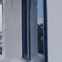 a white building with a blue window and the letters zky on it