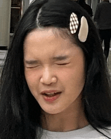 a close up of a young girl making a funny face with her eyes closed .