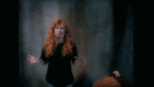 a man with red hair and a black shirt is making a face