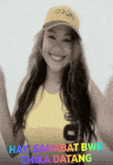 a woman wearing a yellow hat with the words hay sahabat bwr chika datang on it