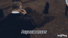 a man in a suit is smoking a cigarette in a foreign language ..