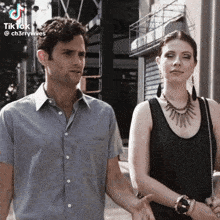 a man and a woman standing next to each other with a tiktok logo in the corner