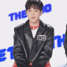 a young man wearing a black jacket with the name into on it