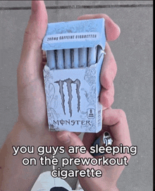 someone is holding a box of monster cigarettes in their hand