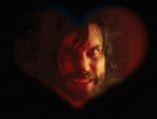 a man with long hair and a beard is in a heart shaped frame