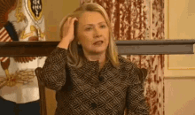 a woman is scratching her head while sitting in a chair .