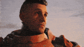 a close up of a man wearing a red armor with the word coca cola on it