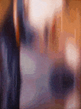 a blurry picture of a person 's face with a purple and orange background