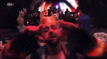 a man with a crown on his head is standing in front of a crowd .