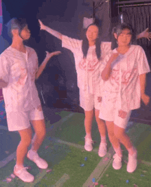 a group of young girls are standing next to each other on a stage and dancing .