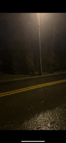 a person standing on the side of a street at night