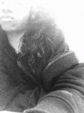 a black and white photo of a woman 's face and arm