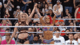 two women in a wrestling ring with one wearing a john t-shirt