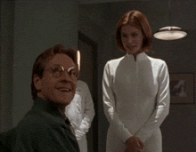 a woman in a white dress stands next to a man