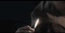 a man is lighting a cigarette with a lighter in his mouth .