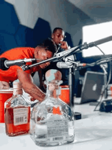 a bottle of patron sits on a table next to a man
