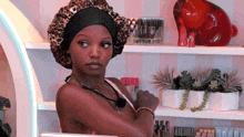a woman wearing a leopard print hat is standing in front of a shelf with bottles of lotion on it