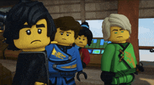 a group of lego ninjago characters standing next to each other with one wearing a green shirt that says lloyd