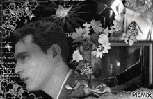a black and white photo of a man surrounded by flowers and butterflies with picmix written on the bottom