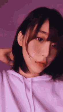 a close up of a woman taking a selfie with her hand behind her head .