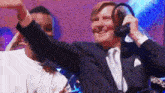 a man in a suit and headphones is dancing with another man