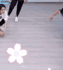 a girl in a nike shirt is kneeling on the floor next to a flower