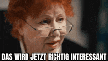 a woman with red hair and glasses is making a funny face and says das wird jetzt richtig interessant .