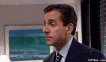 a man in a suit and tie is standing in front of a painting .