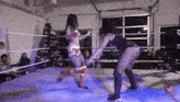 two women are wrestling in a ring with a christmas tree in the back