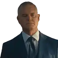 a man in a suit and tie looks at the camera with a serious look on his face