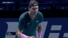 a tennis player wearing a green shirt and pink wristbands