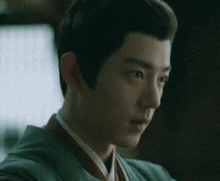 a close up of a young man 's face with a very long haircut .