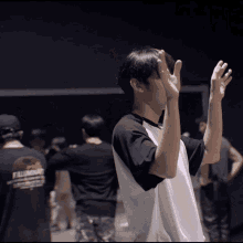 a man wearing a california shirt is covering his face with his hands