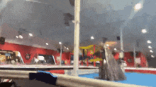 a blurry picture of a gym with a blue floor and a red wall