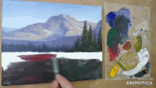 a painting of a mountain landscape is being painted on a canvas next to a palette that says made in animotica