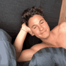 a shirtless man with a red bracelet on his wrist