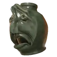 a green vase with a face on it with its mouth open