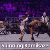 a wrestler is spinning another wrestler in a wrestling ring .