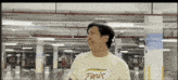 a man in a fenix shirt is standing in a parking garage