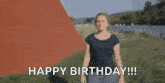 a woman is standing in a field with the words `` happy birthday ! ''
