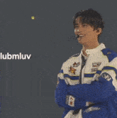 a young man wearing a blue and white jacket with nct on it