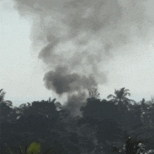 a large cloud of smoke is coming out of a building